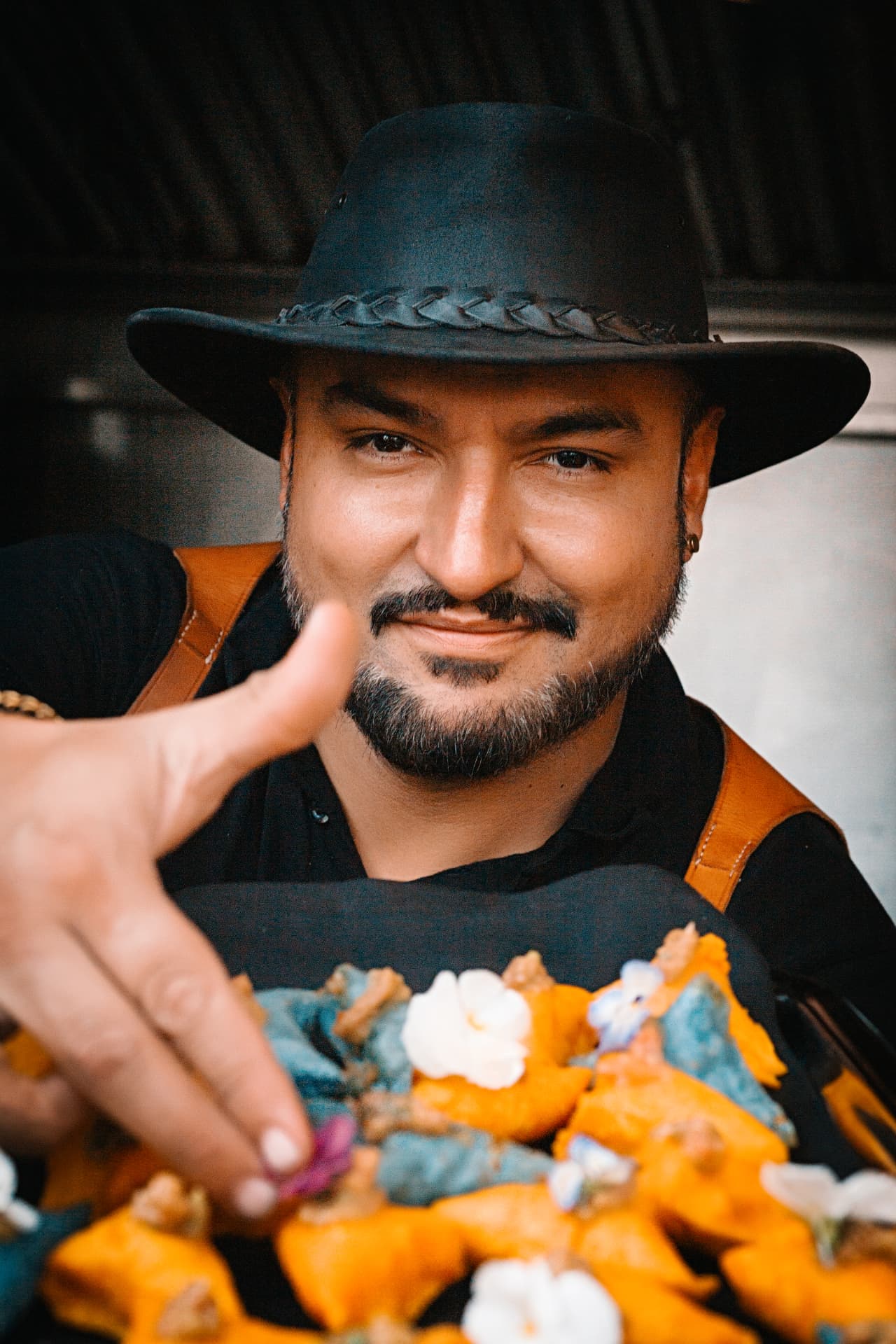 El Momento host presenting a plate of Colombian food