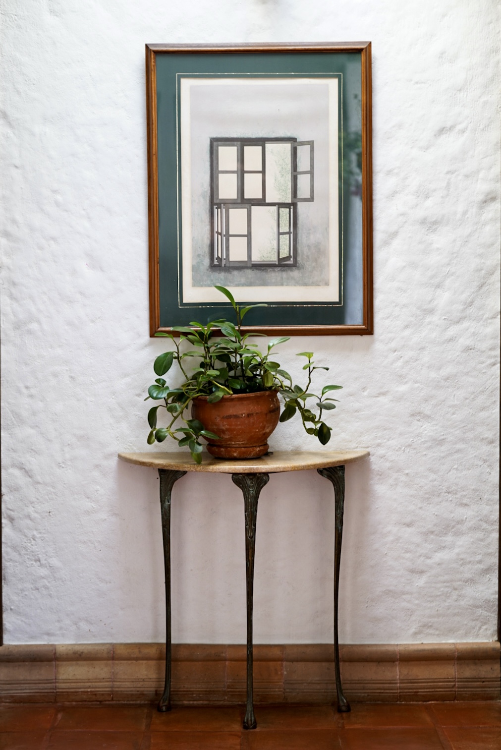 Framed print above a marble console table in the corridor