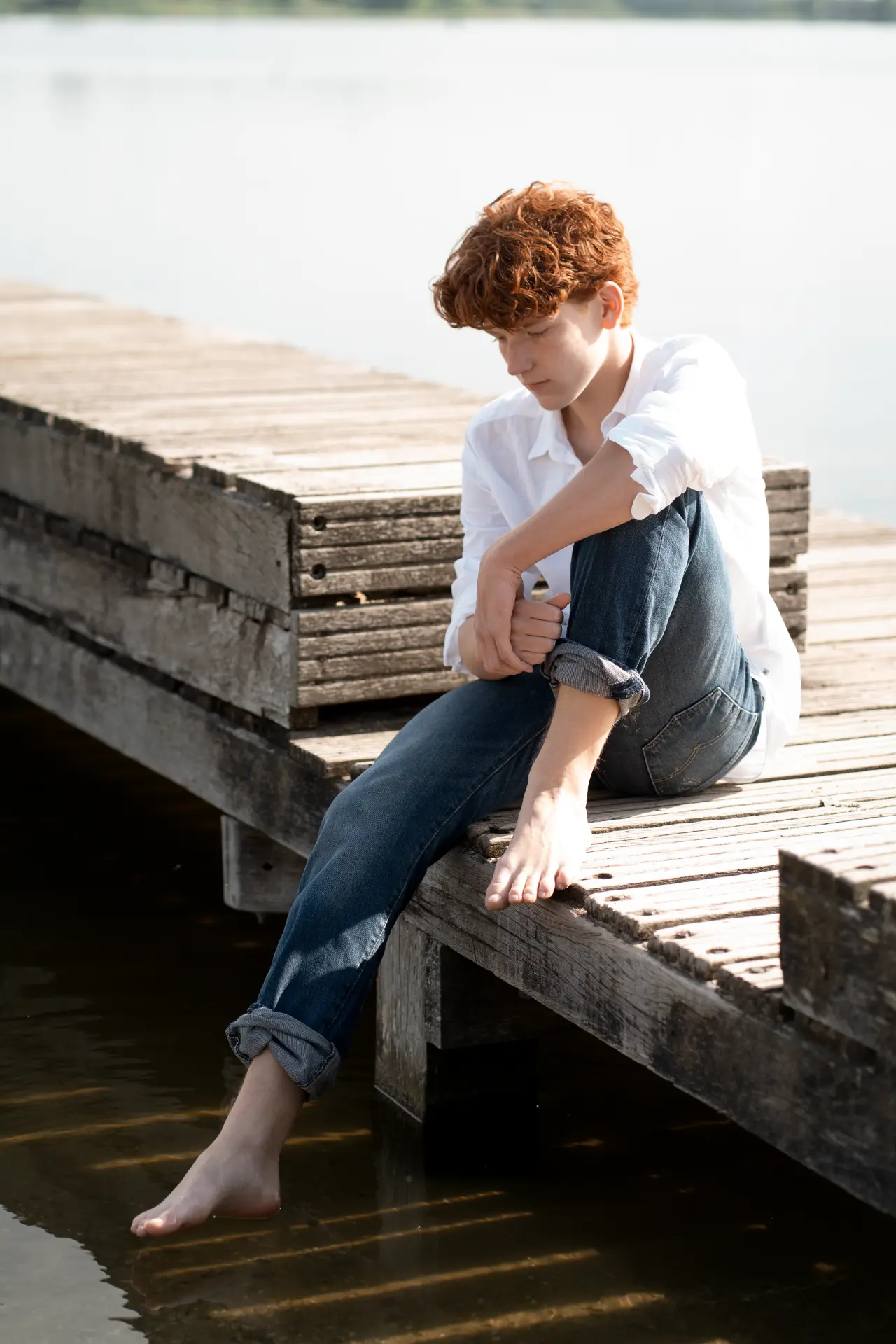 Wide portrait of Shey seated beside the water