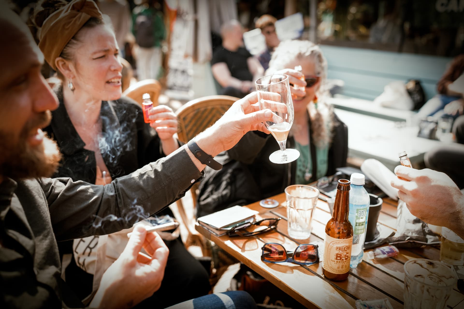 Friends raising a glass at a sunlit table