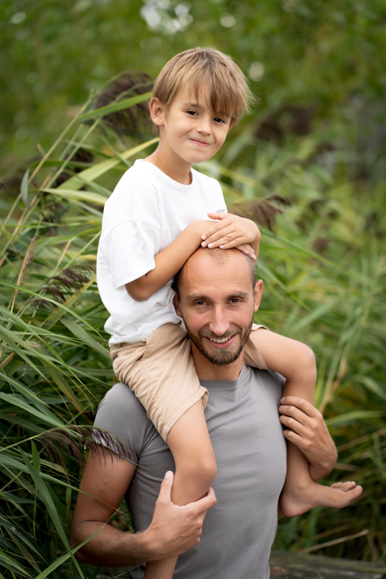 Father carrying his son on his shoulders in the reeds