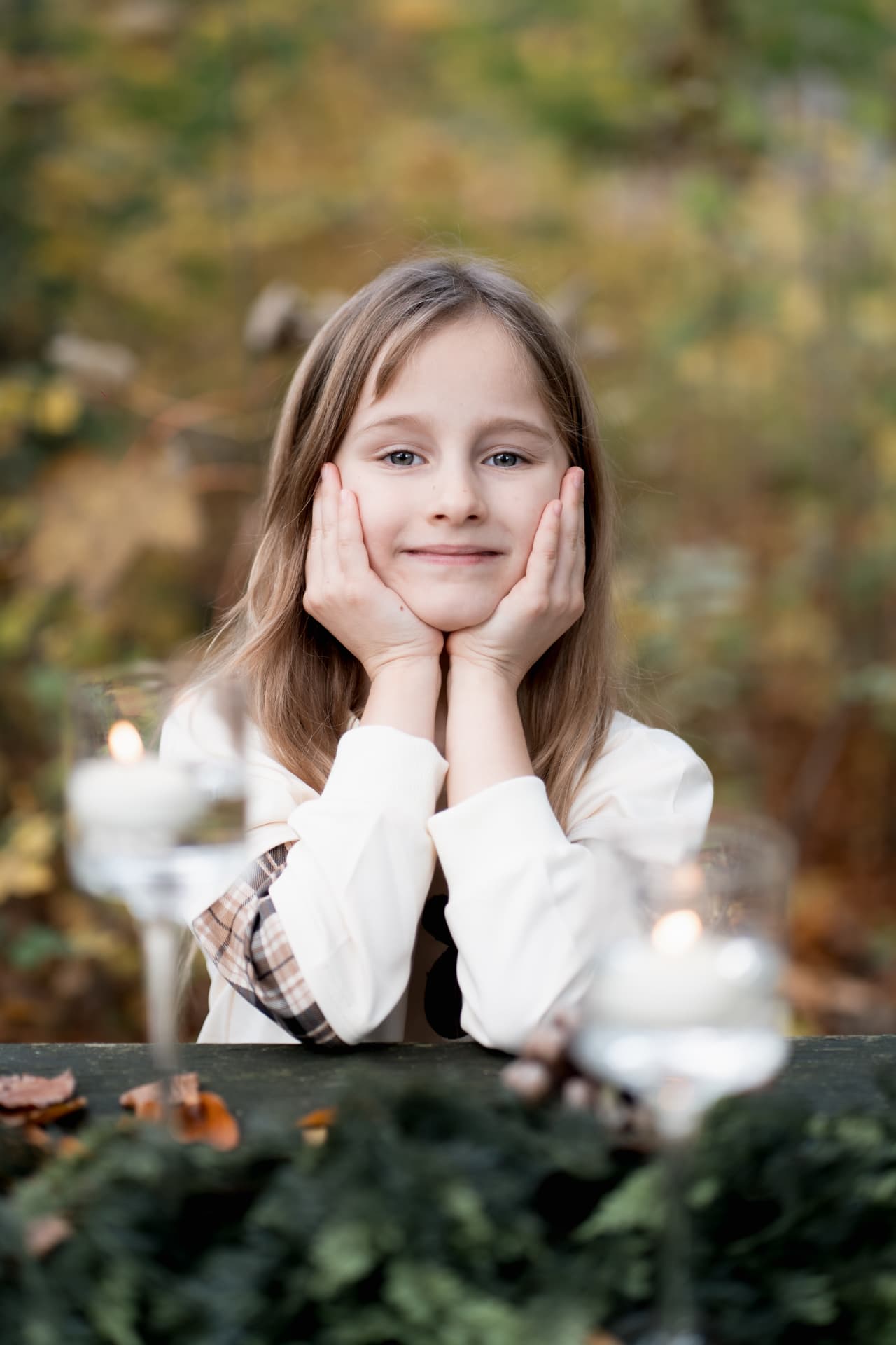 Girl resting her face in her hands at the candlelit table
