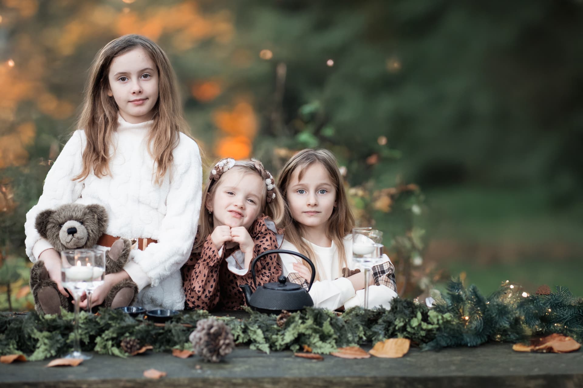 Three girls gathered with a teddy bear for autumn tea