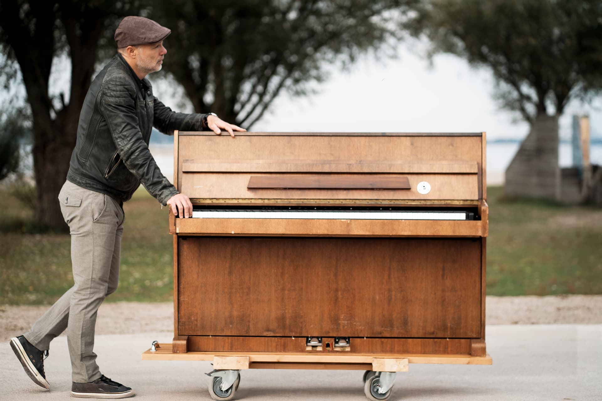 Peter wheeling his piano along the water
