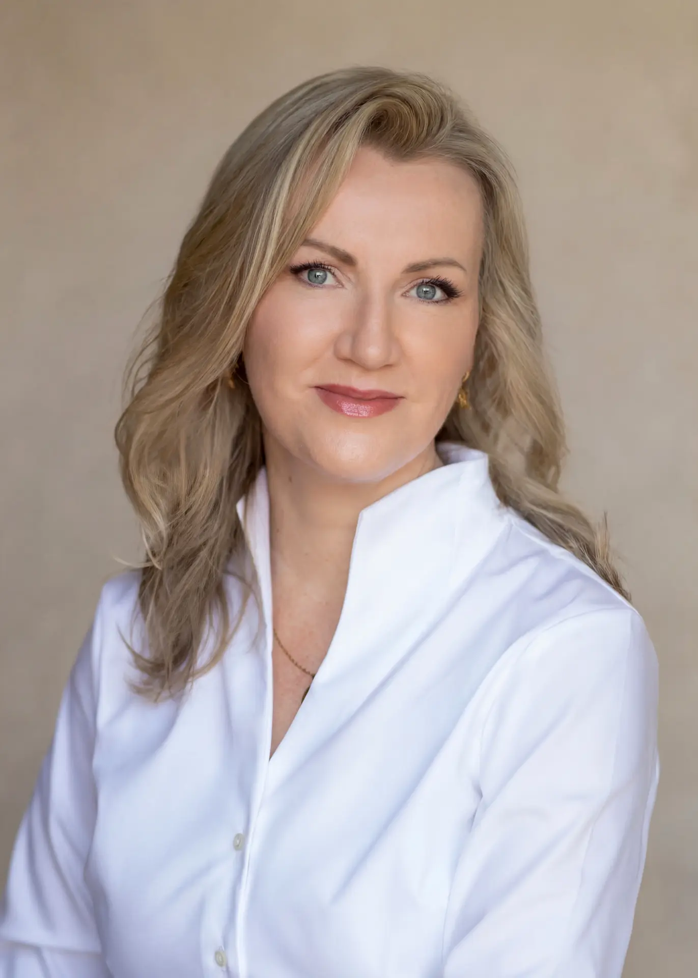 Woman in a white shirt against a soft beige backdrop