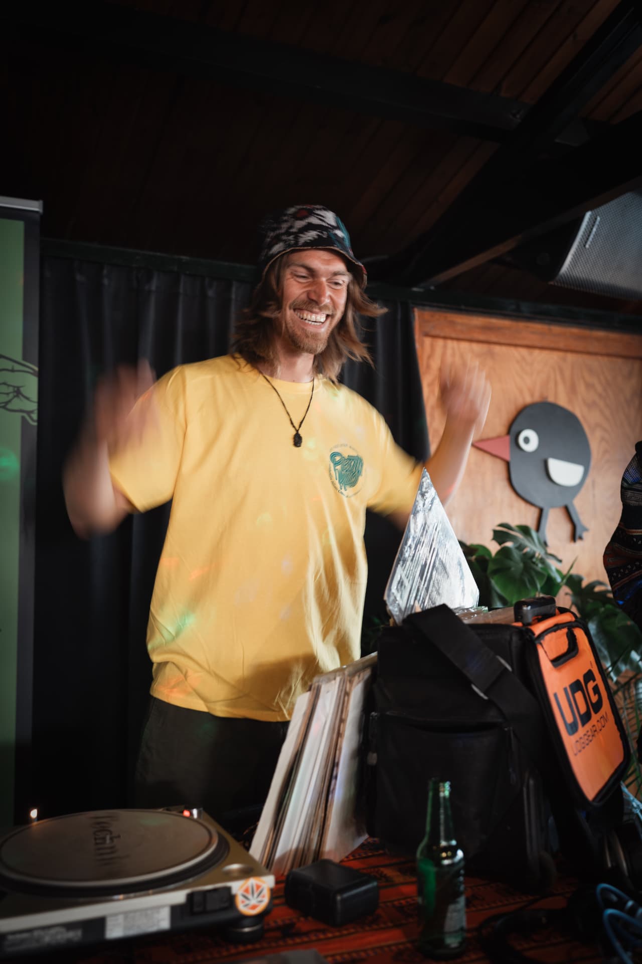 DJ in a yellow shirt behind the turntables