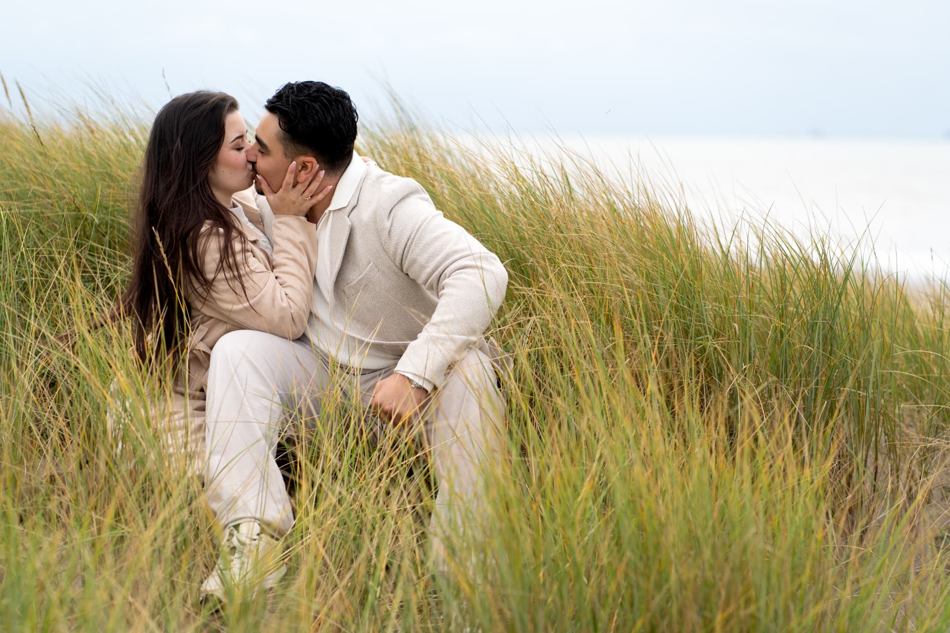 N and Y sharing a kiss among the dune grass