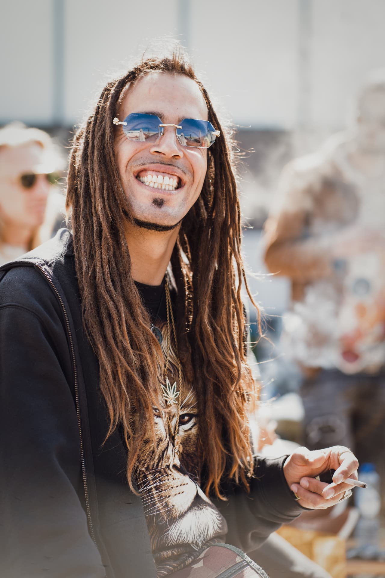 Smiling guest with long dreadlocks in the sunlight at Plenty 420
