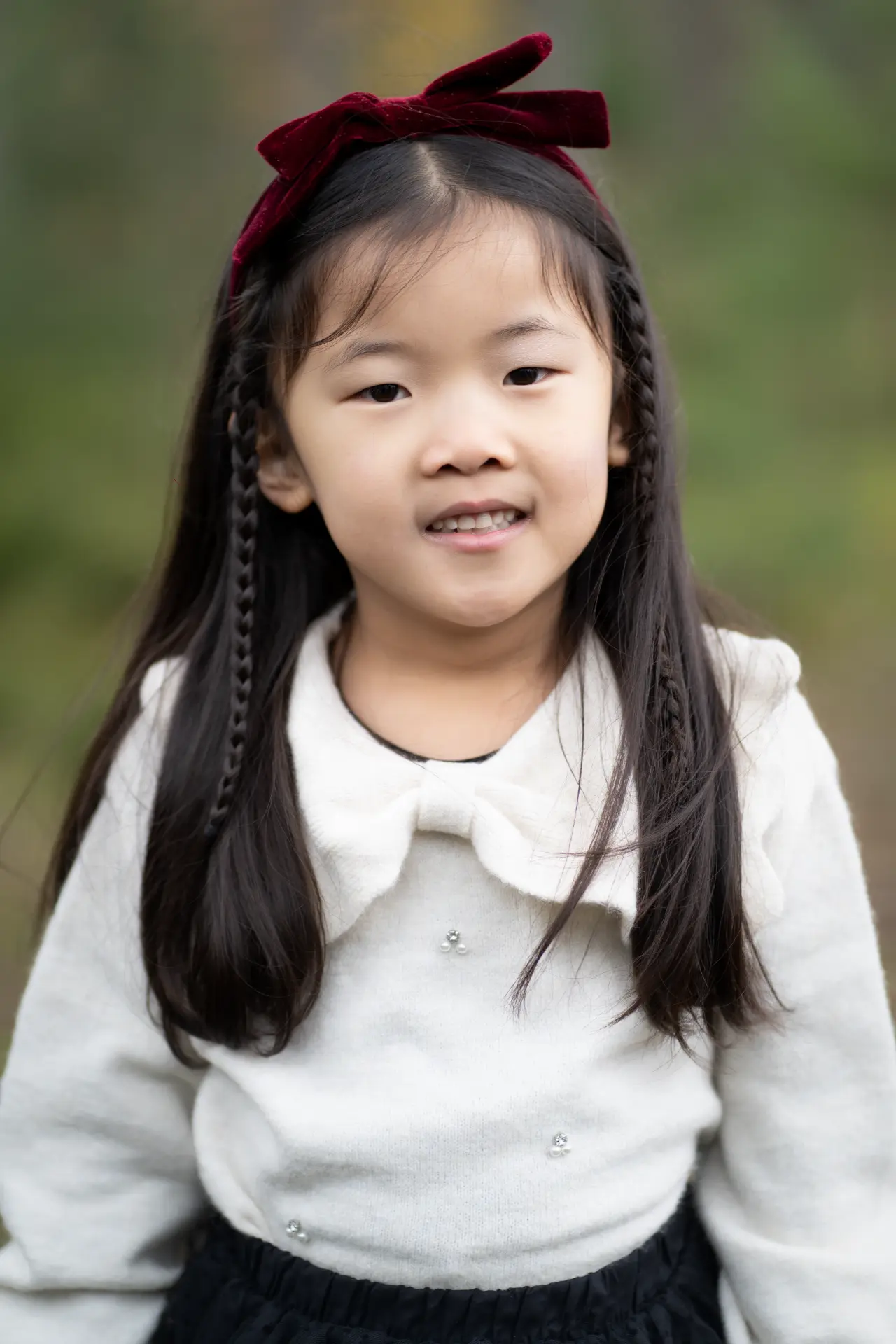 Portrait of a girl with a burgundy velvet bow