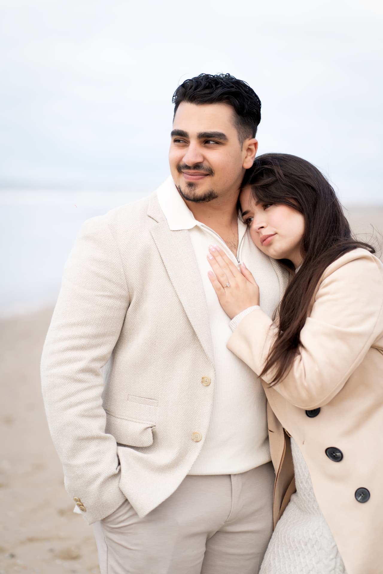 N and Y standing close together on the beach