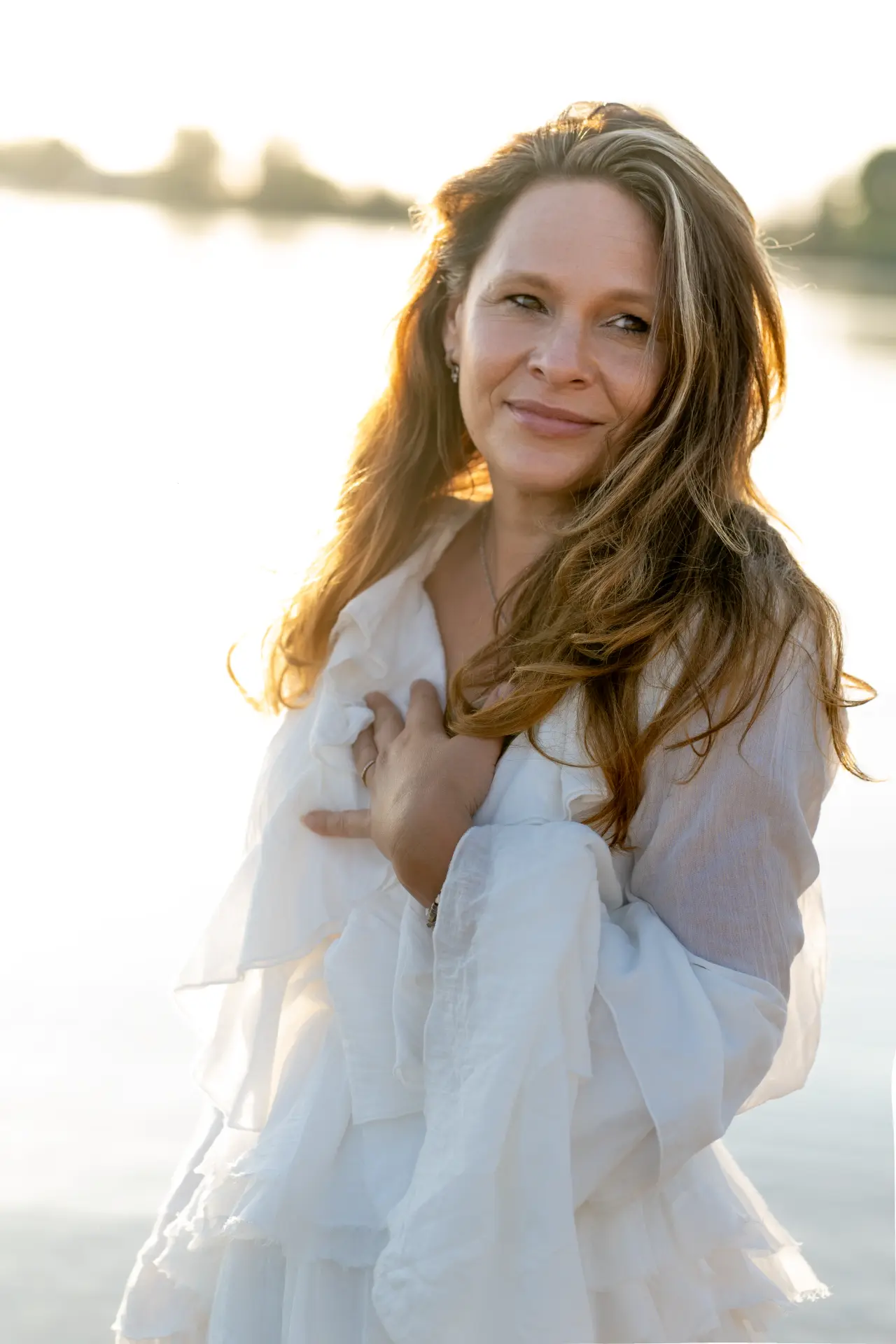 Marjolijn in white beside the sunlit water