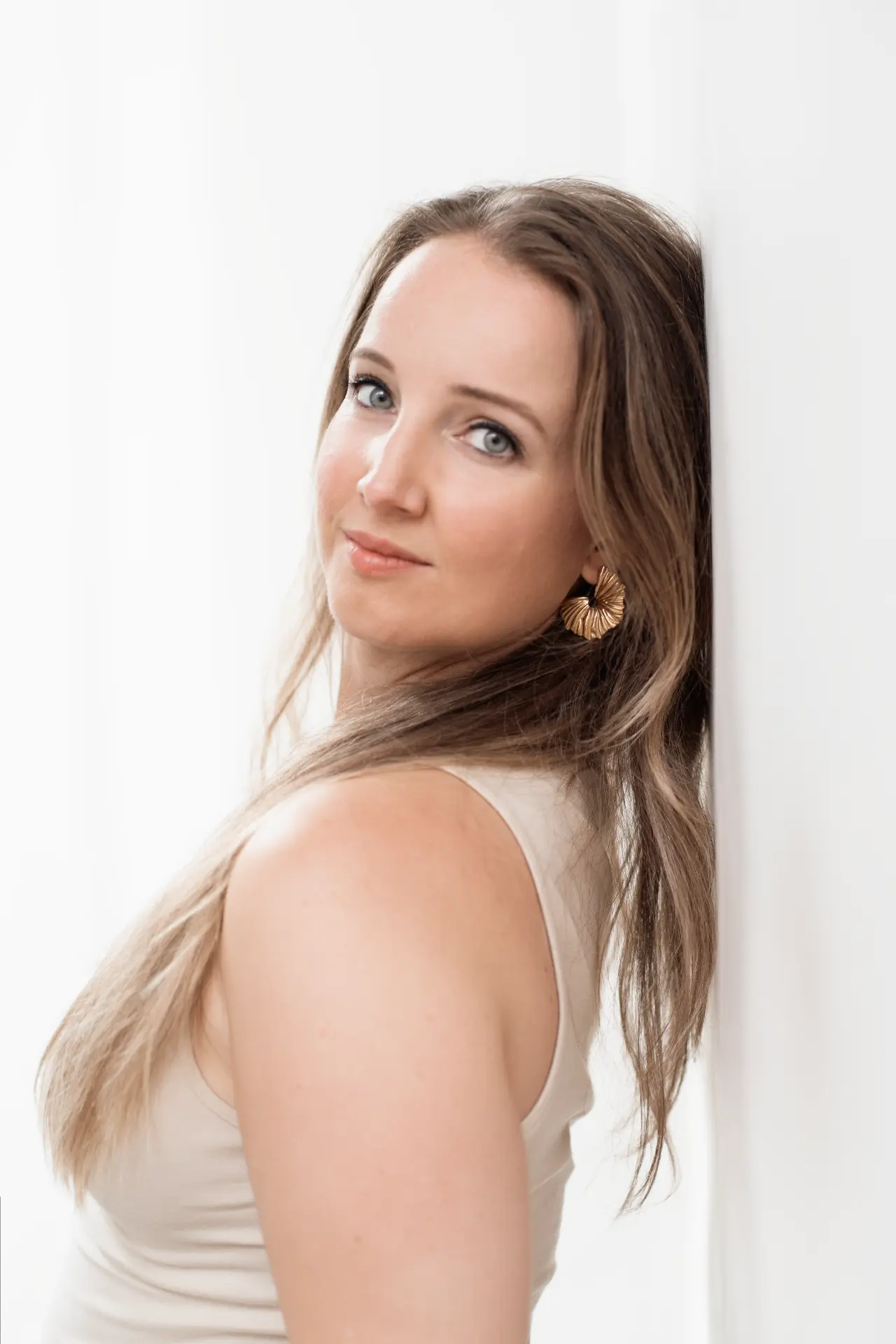Close portrait of Marina against a light wall