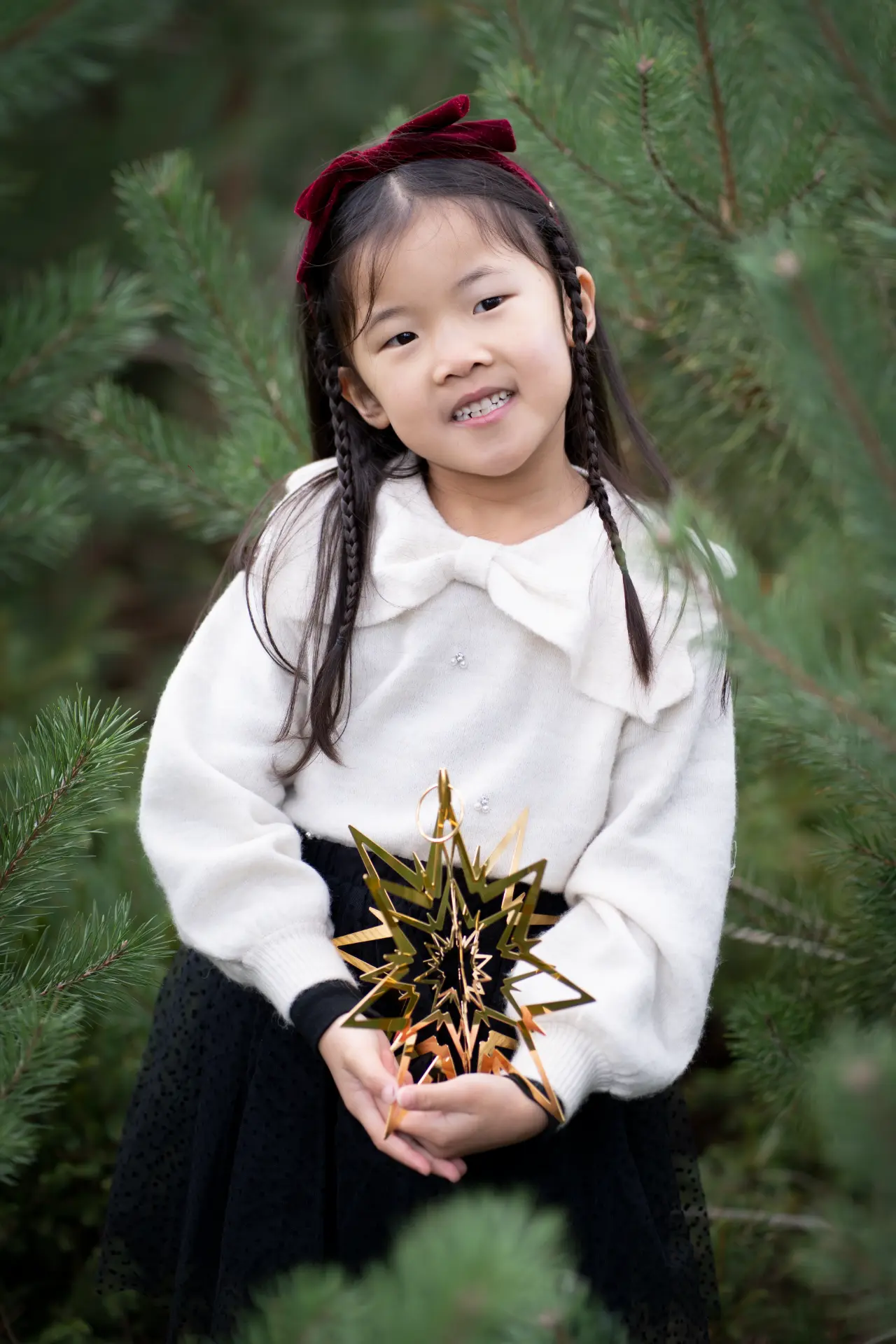 Girl smiling among the pine branches