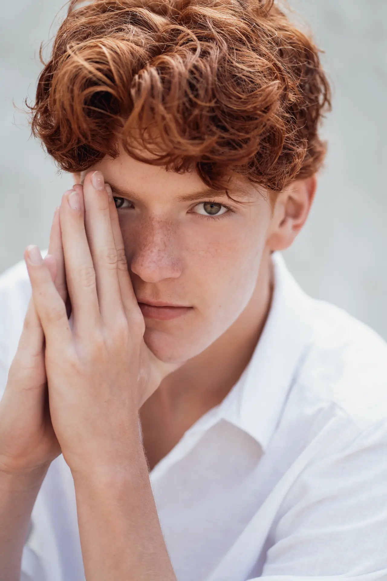 Close portrait of Shey with his hands resting against his face