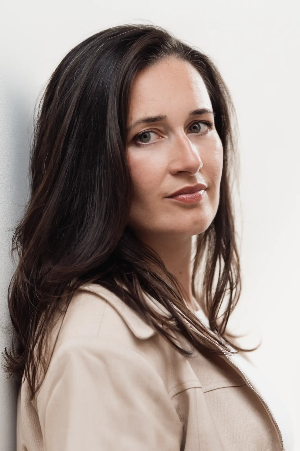 Close portrait of Suzana against a pale wall