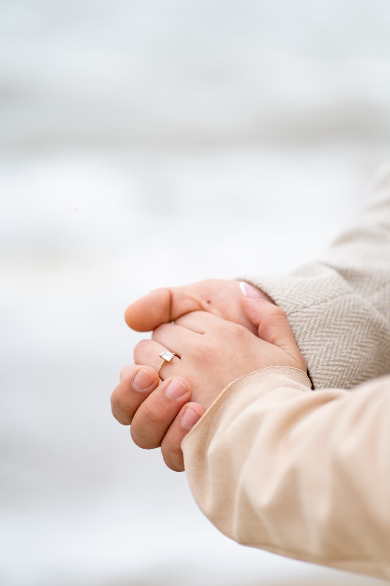 Close portrait of the engagement ring in their joined hands