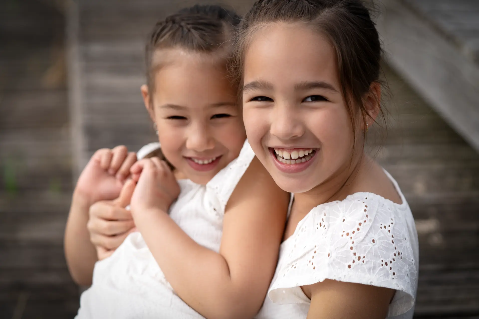 Close portrait of two sisters laughing cheek to cheek