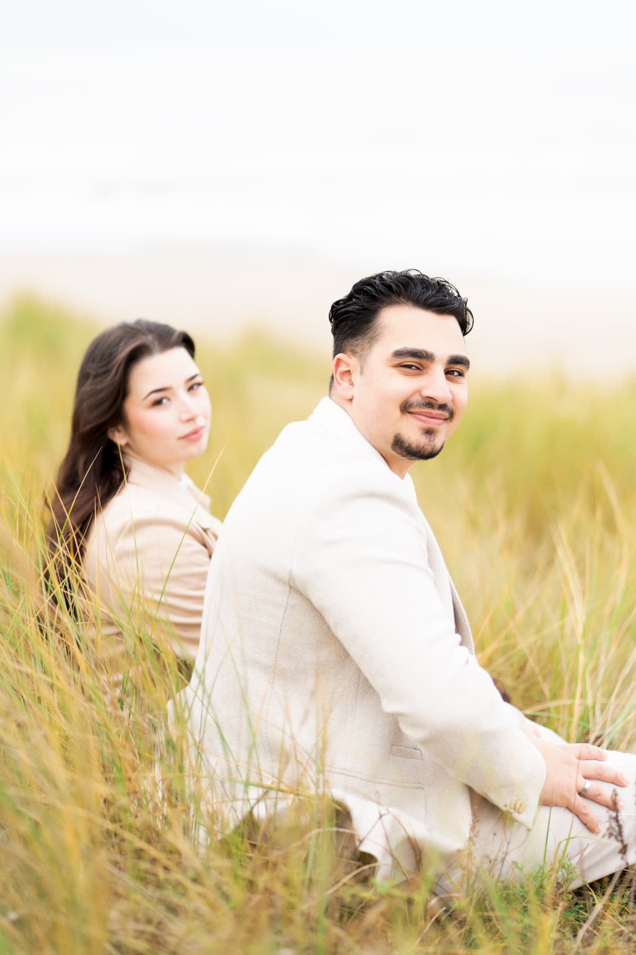 N and Y seated together among the dune grass