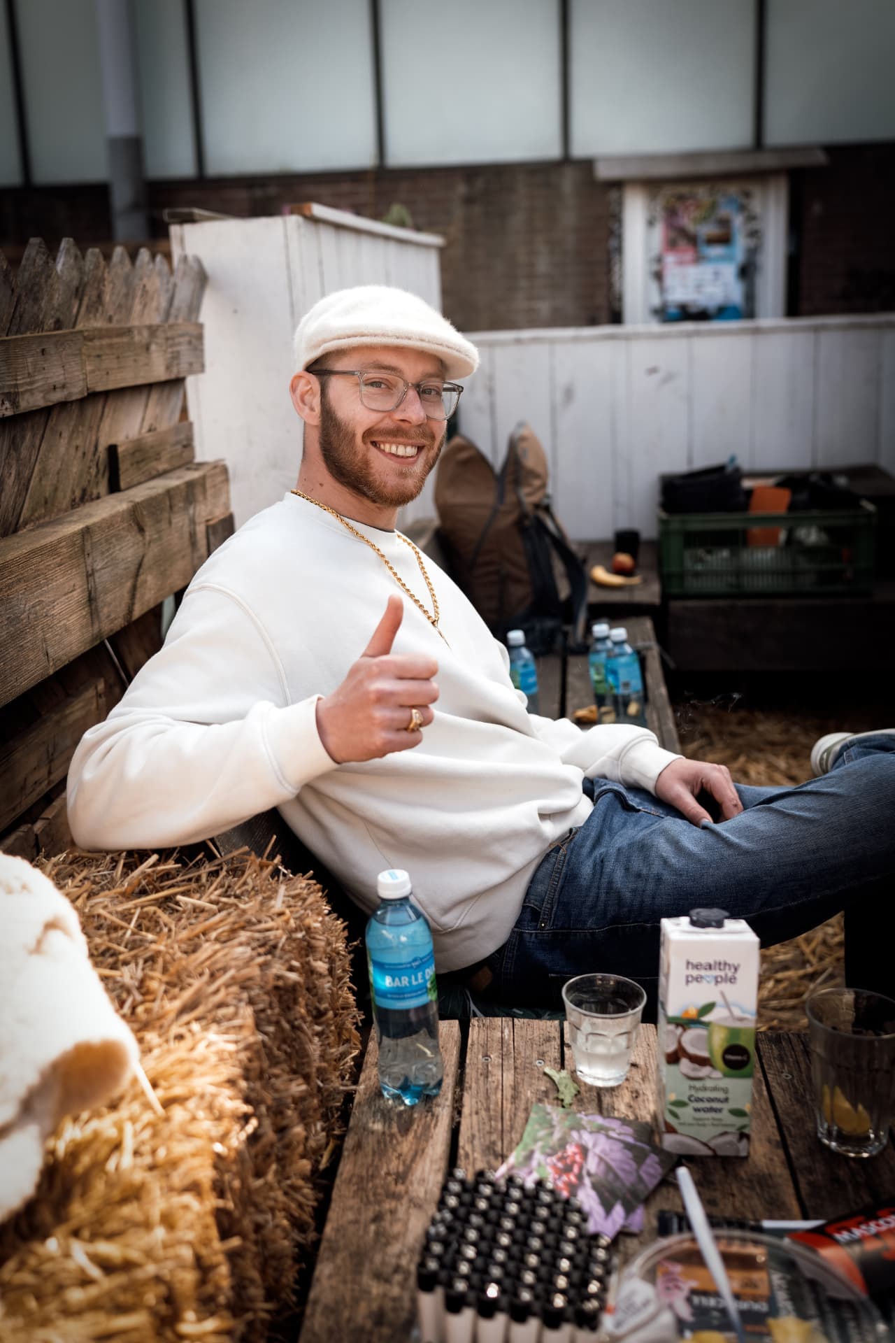 Guest in a white cap relaxing on a hay bale
