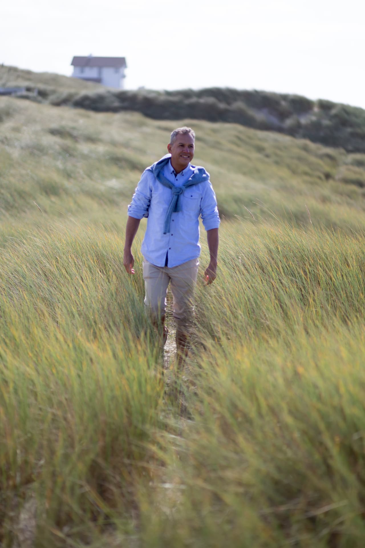 Rey walking through tall coastal grass