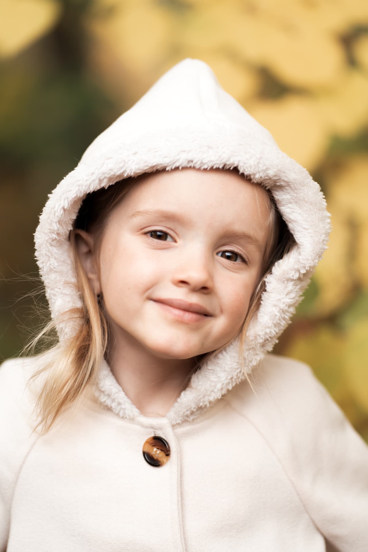 Close portrait of the youngest girl in a white hooded coat