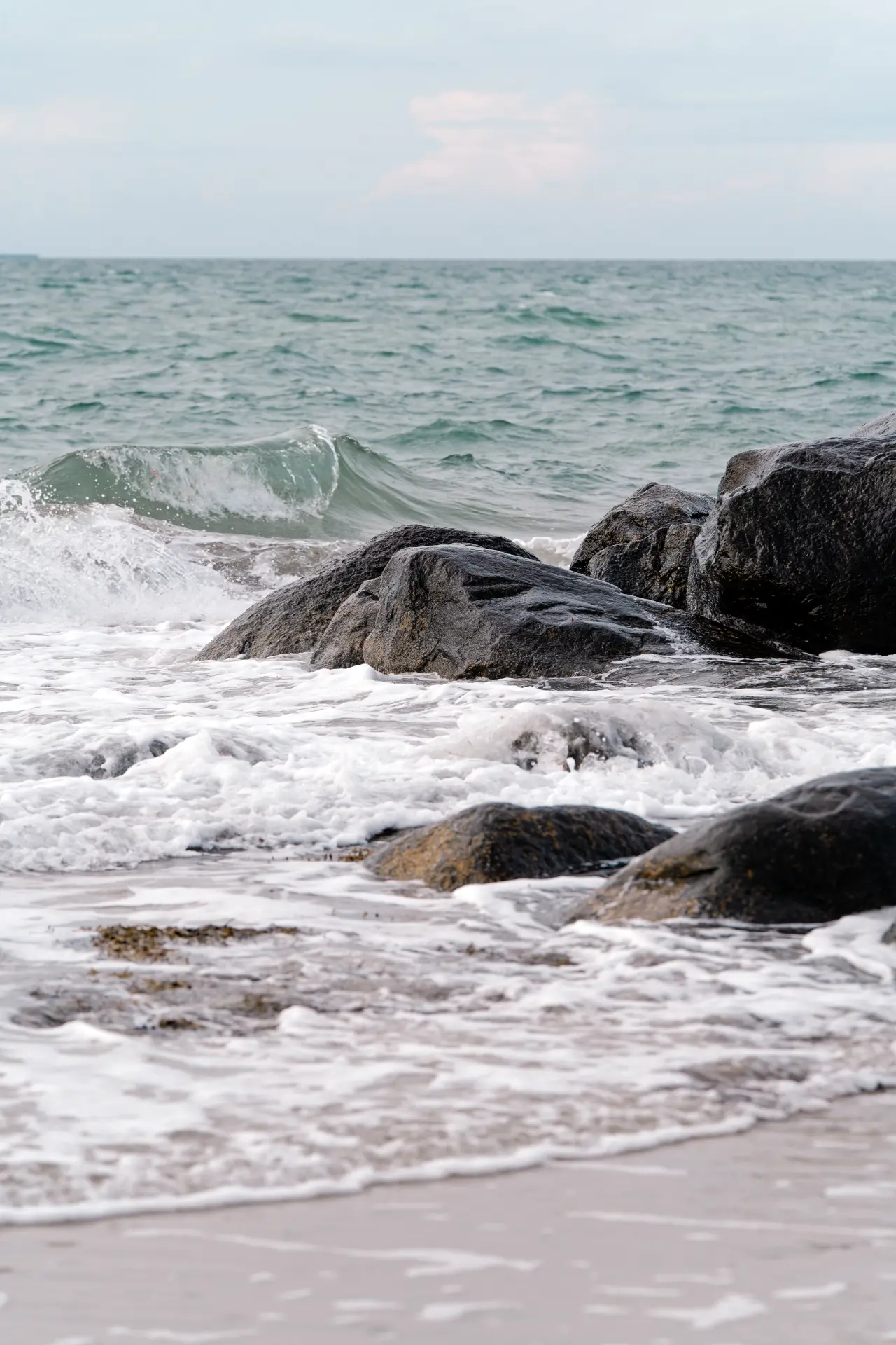 Waves breaking over dark rocks on a northern shoreline