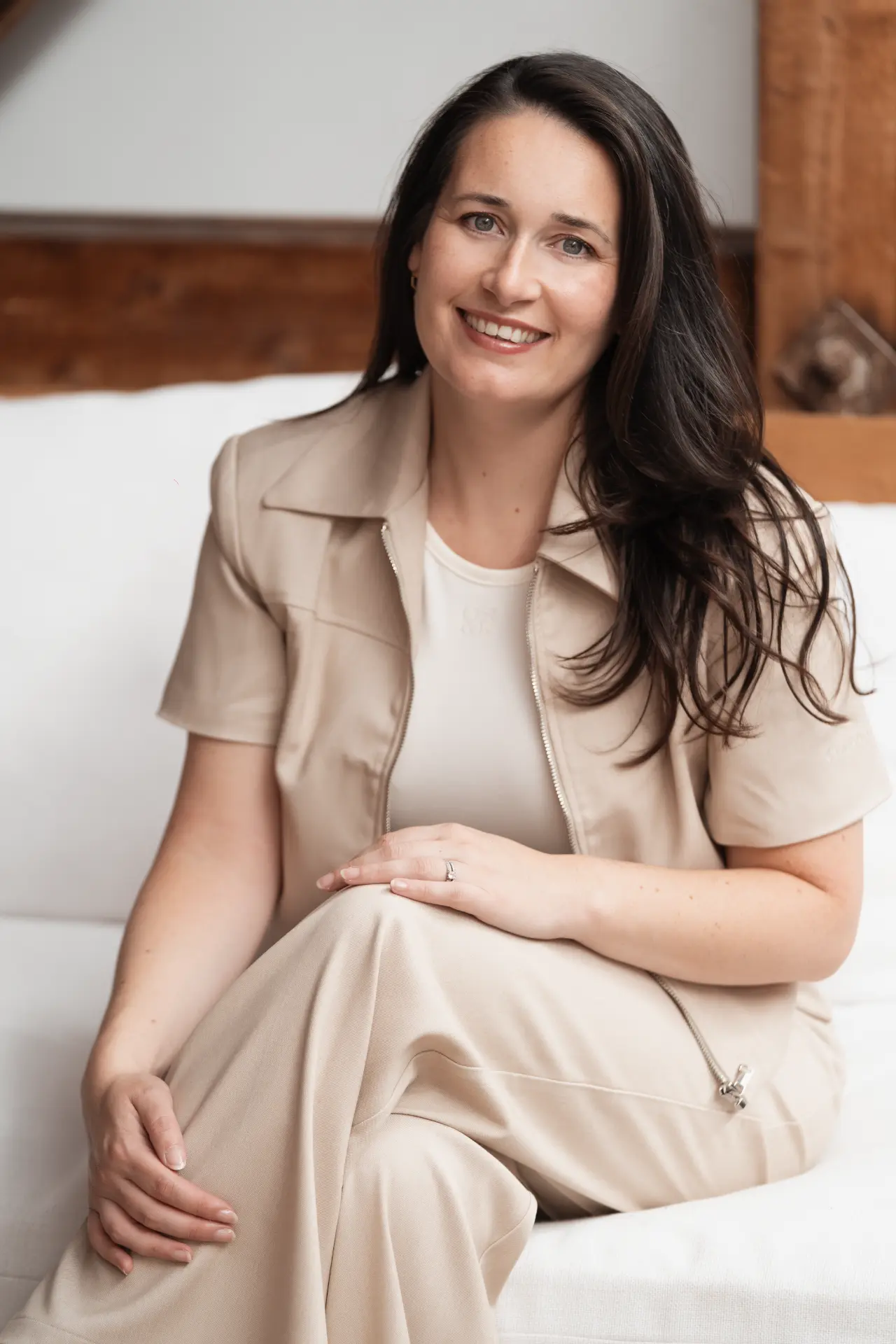 Suzana seated and smiling in a warm interior