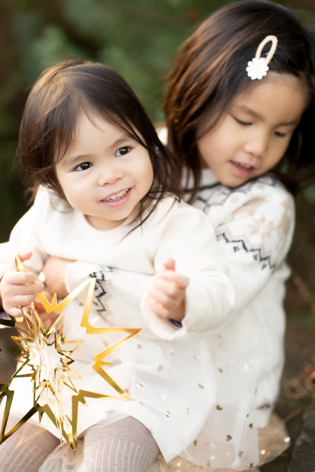 Two sisters sharing a golden Christmas star