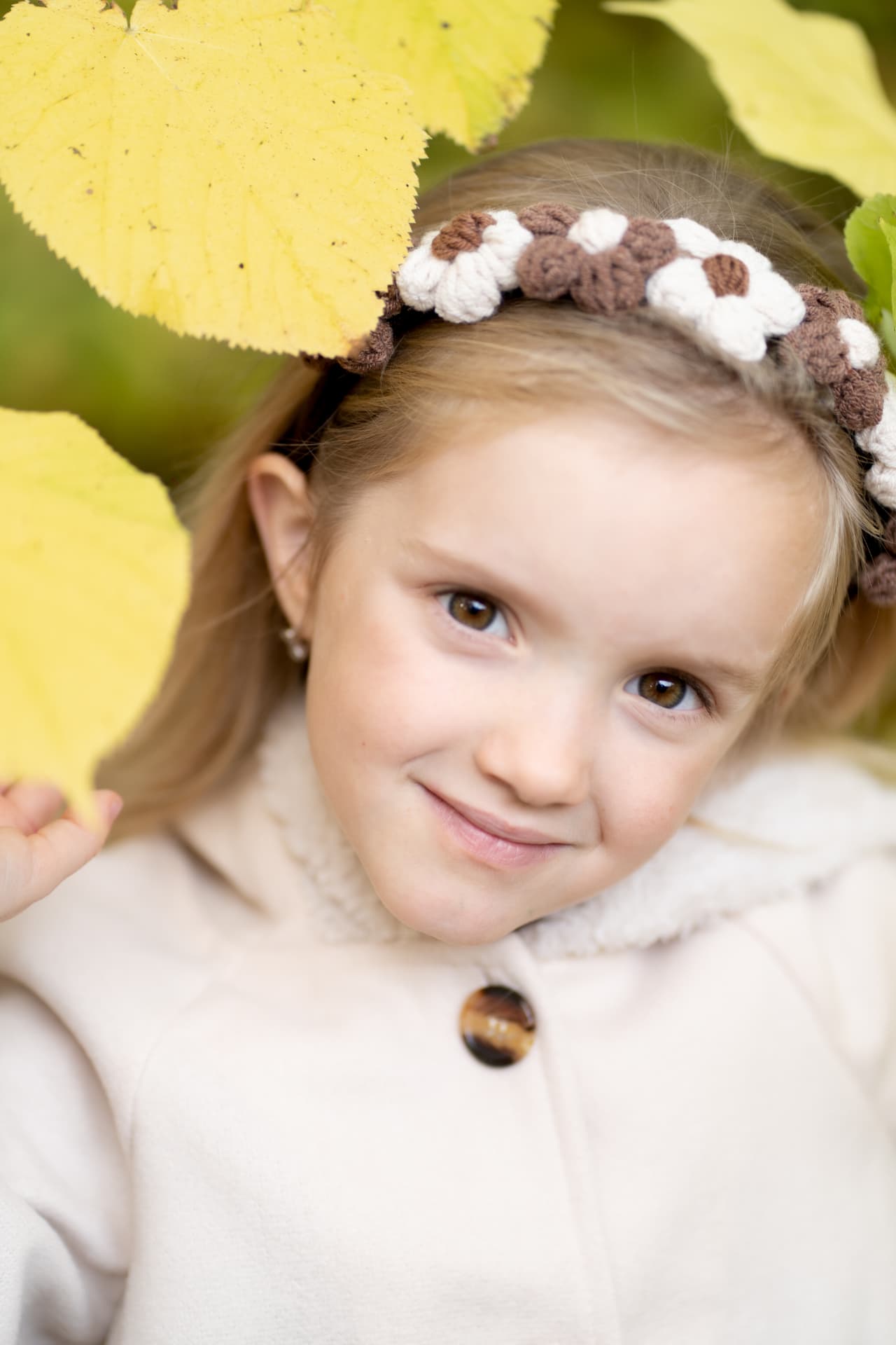 Young girl framed by bright yellow autumn leaves