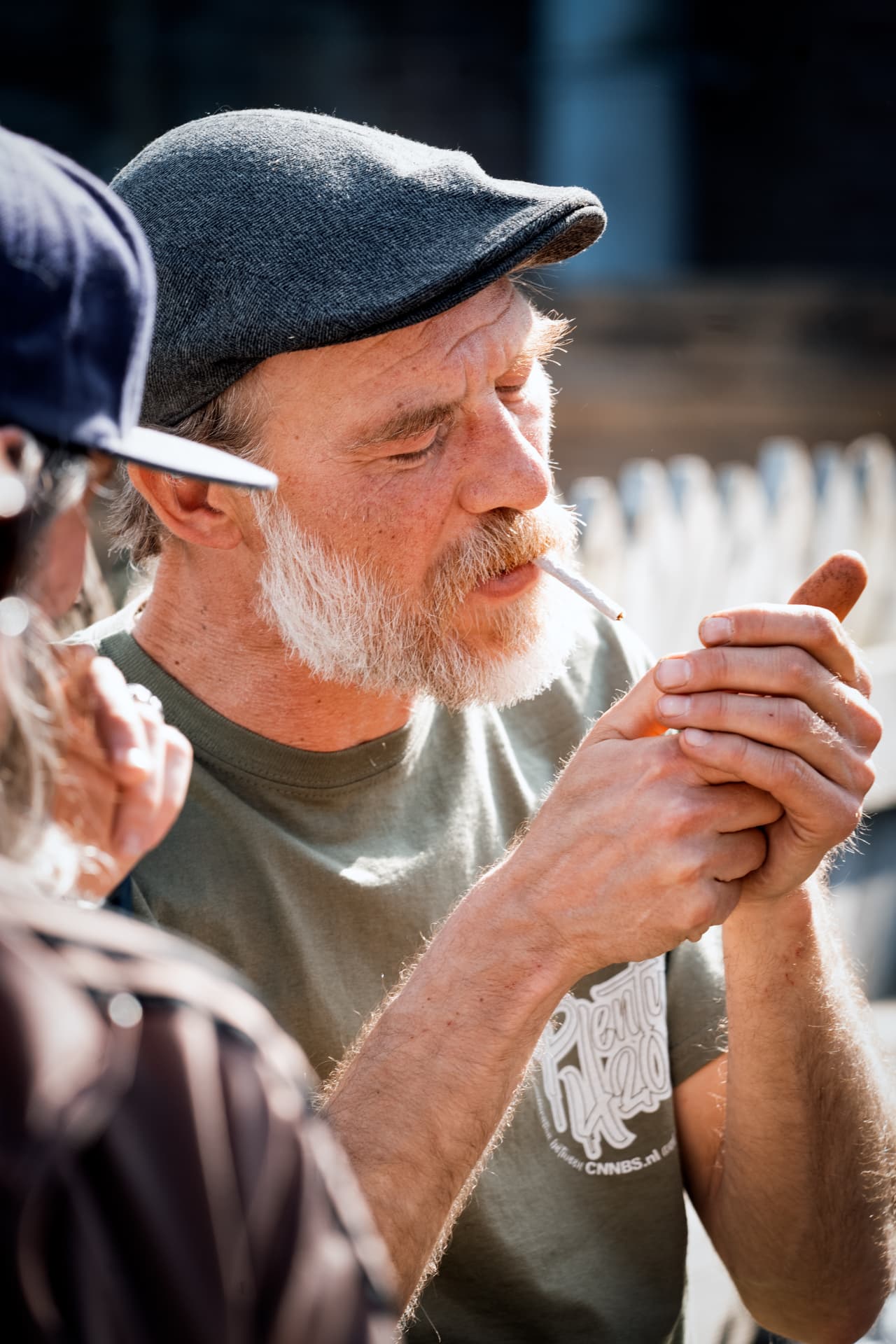 Guest in a flat cap lighting up